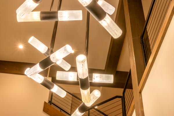 Glass-tube chandelier and timber beams seen from below