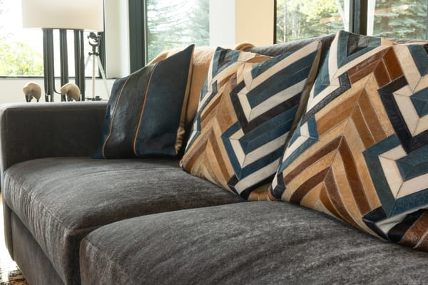 Charcoal sofa with patterned hide pillows