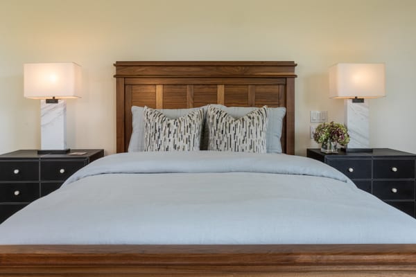 Walnut bed with marble lamps on black leather nightstands