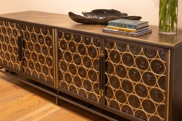 Long sideboard with brass-trimmed circle doors, books and a dark sculptural bowl