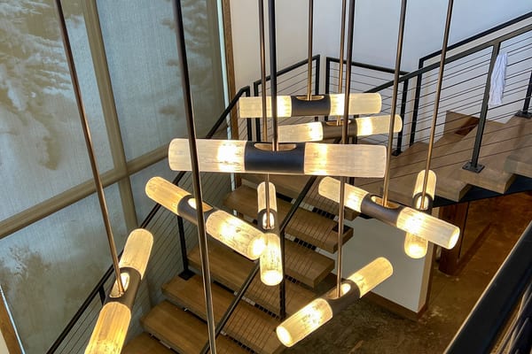 Glass-tube chandelier hanging through the stairwell, seen from above