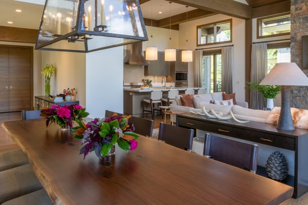 Live-edge dining table with fresh flowers, open to the living room and kitchen