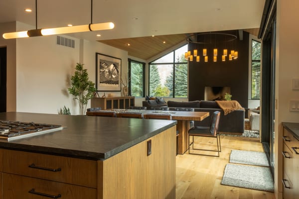View from the kitchen island across the dining table to the living room fireplace