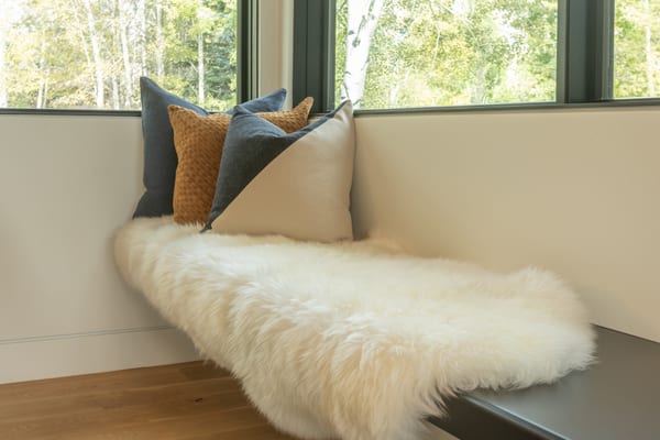 Window bench with a sheepskin throw and blue and tan pillows