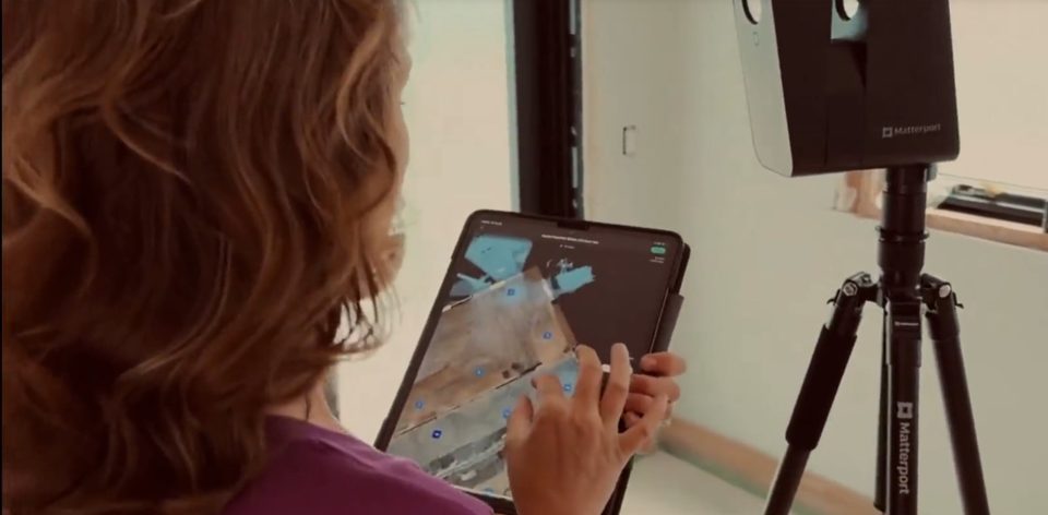 Scanning a room with a Matterport camera, with the scan on a tablet